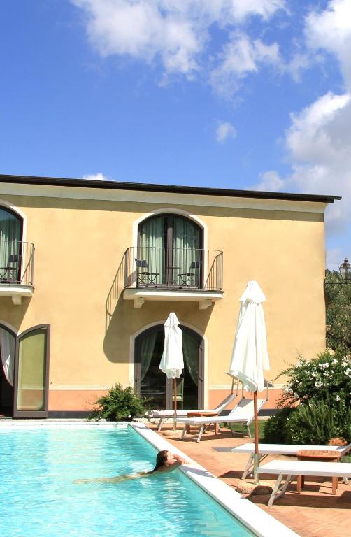 a person laying in a swimming pool next to a building at Villa Agnese in Sestri Levante