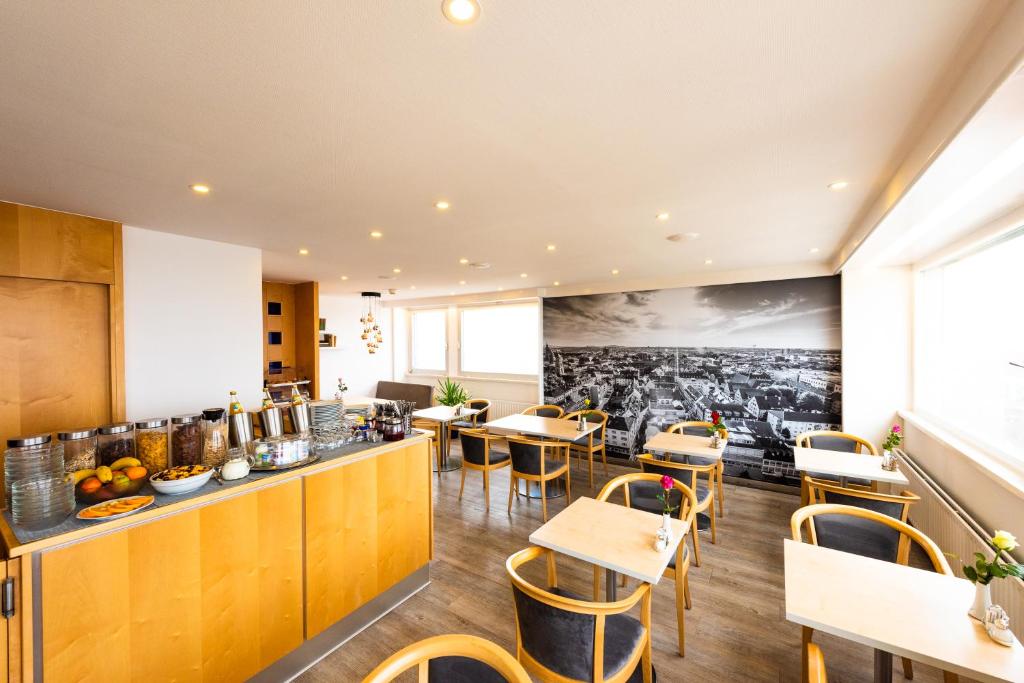 a restaurant with tables and chairs and a bar at City Hotel Heilbronn in Heilbronn