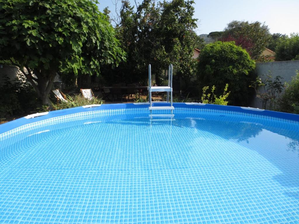 une piscine bleue avec une chaise assise dans l'établissement Lou Cigalon, à Marseille