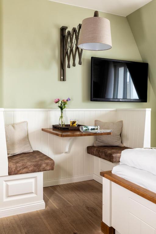 a bedroom with a bed and a tv on the wall at Hotel Zweite Heimat in Sankt Peter-Ording