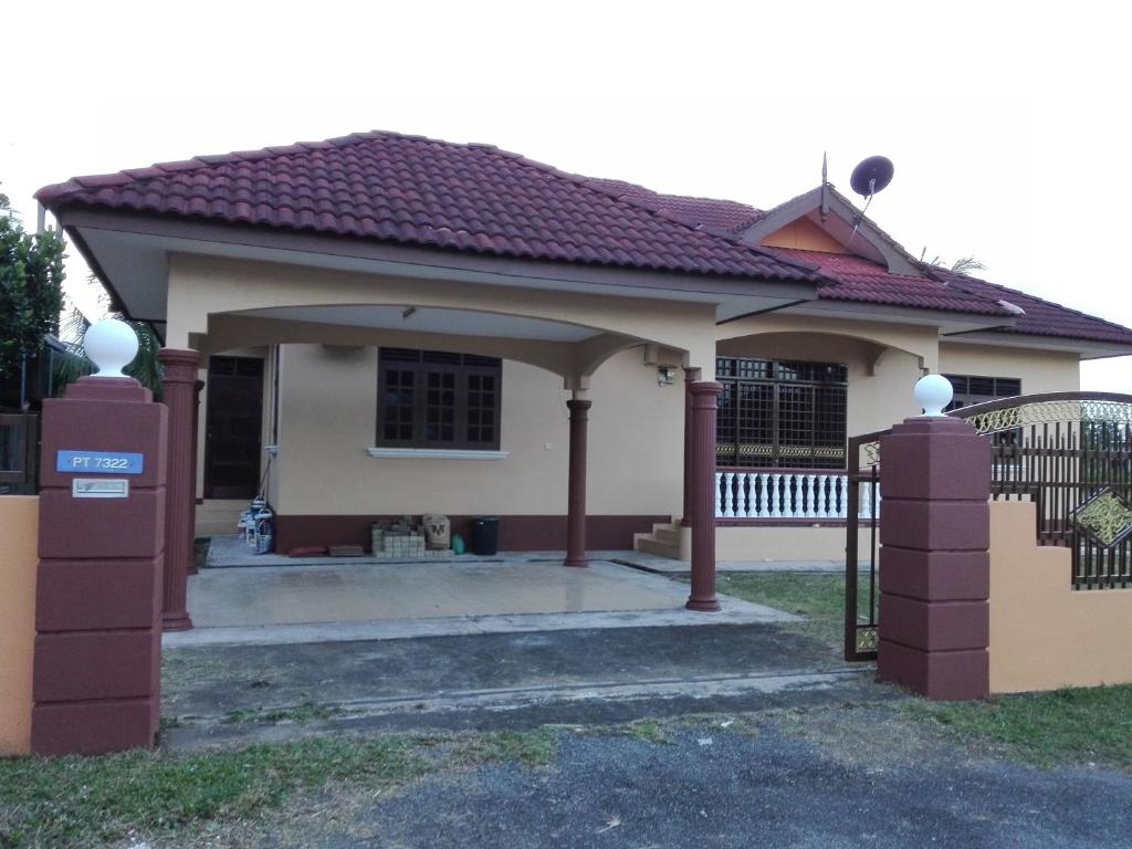 ein kleines weißes Haus mit einem Tor und einem Zaun in der Unterkunft Homestay Ahmad Taman Mas Bukit Payong Terengganu in Marang