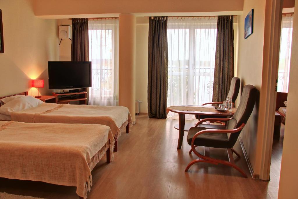 Televízia a/alebo spoločenská miestnosť v ubytovaní Apartamenty & Restauracja Janus