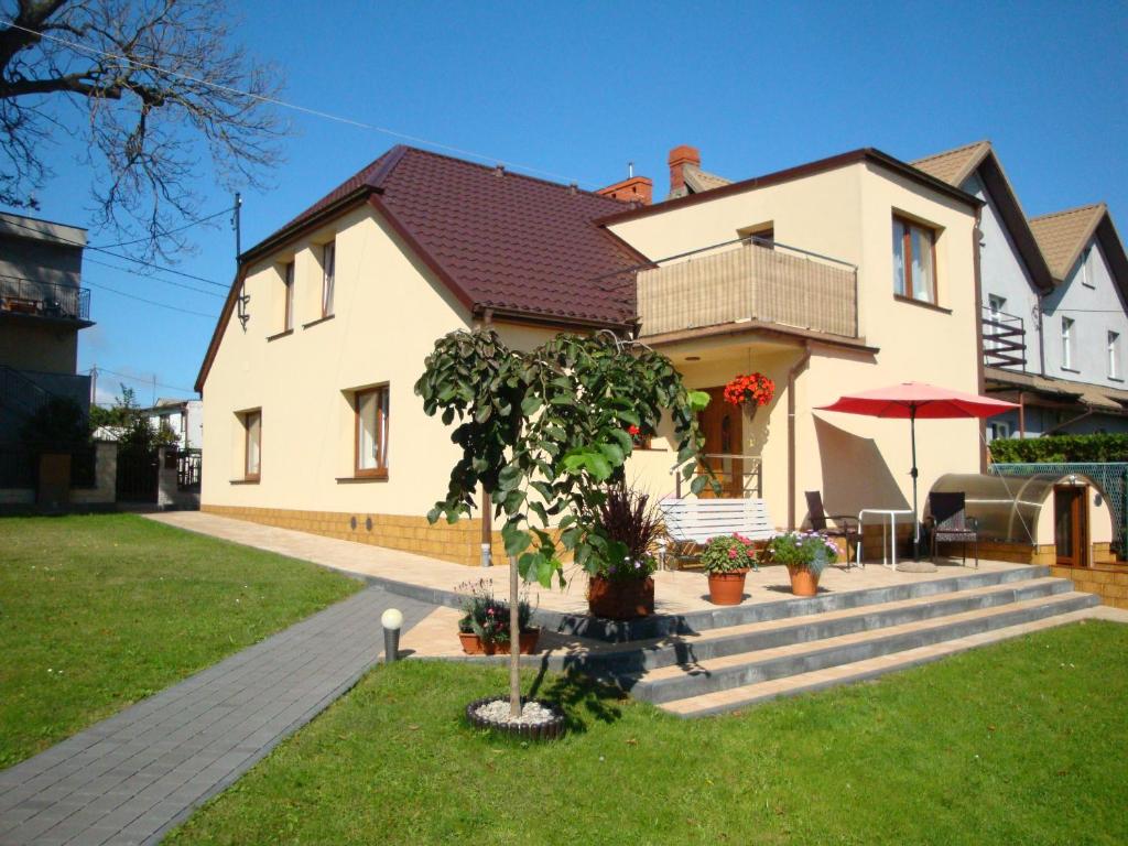 une maison avec un arbre dans la cour avant dans l'établissement Lucy, à Władysławowo