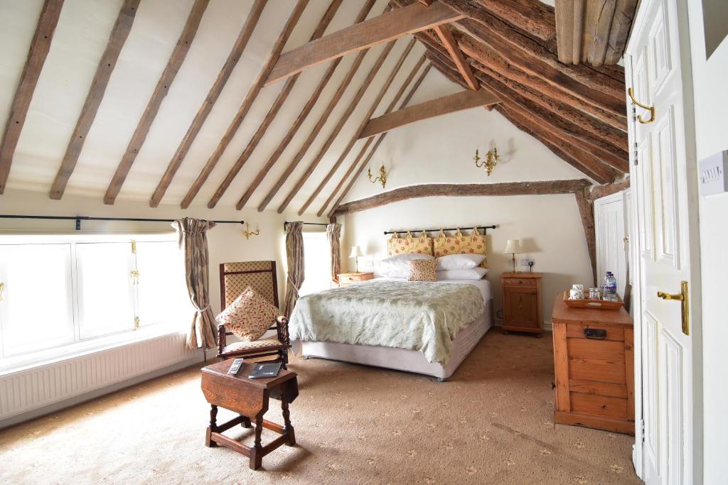 1 dormitorio con cama y techo de madera en The Abbey Hotel & Apartments, en Bury Saint Edmunds
