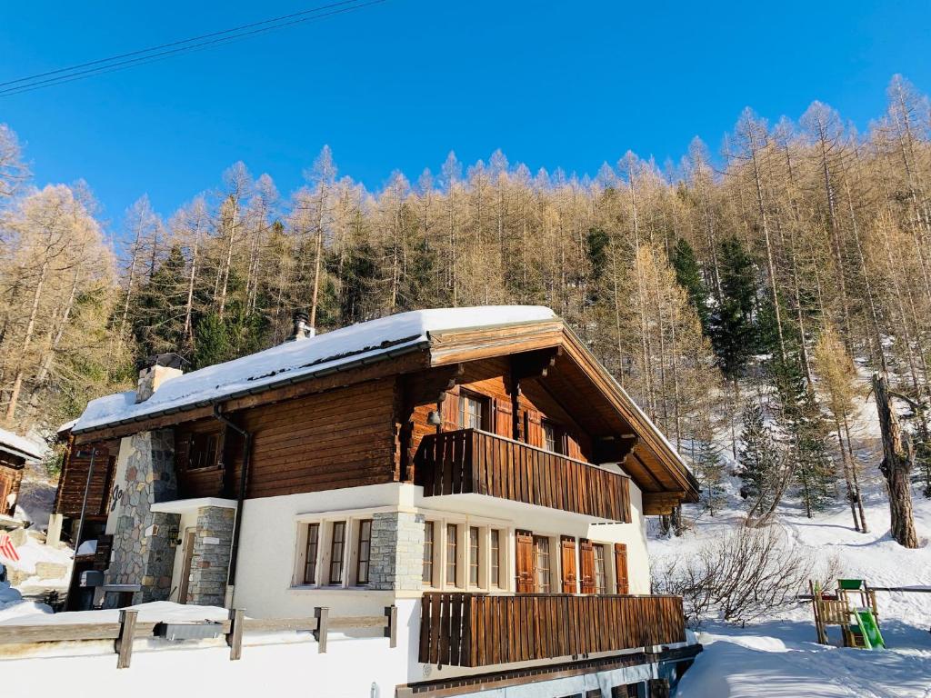 a log cabin in the snow with trees at Chalet Josianne in Saas-Fee