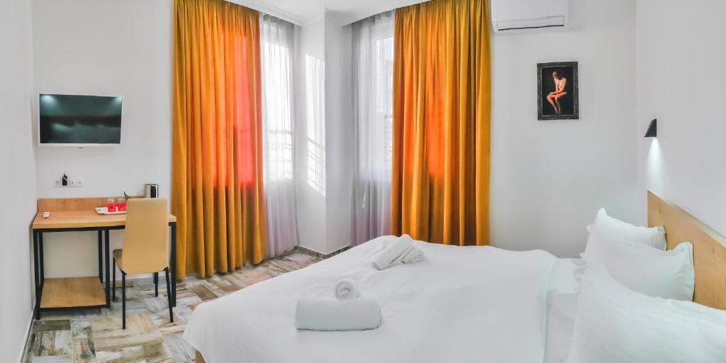 Habitación de hotel con 2 camas y escritorio en WESTAY Hotel en Tiflis