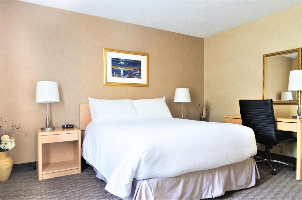 a hotel room with a large bed and a desk at Mount Peyton Resort & Conference Centre in Grand Falls -Windsor