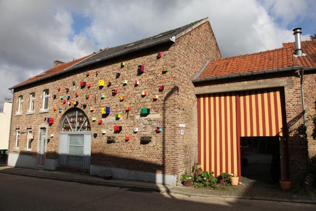 un bâtiment en briques avec un mur orné d'objets colorés. dans l'établissement B&B De Henehoeve, à Heks