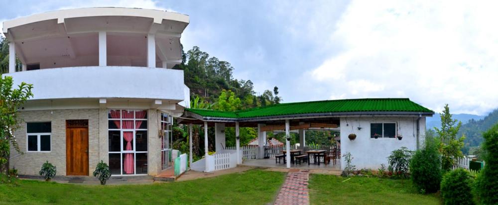 une petite maison avec un toit vert et une table dans l'établissement Victorian Guest, à Bandarawela