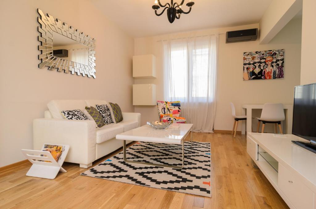 a living room with a white couch and a table at Rise & Shine Sofia Luxury Apartment in Sofia