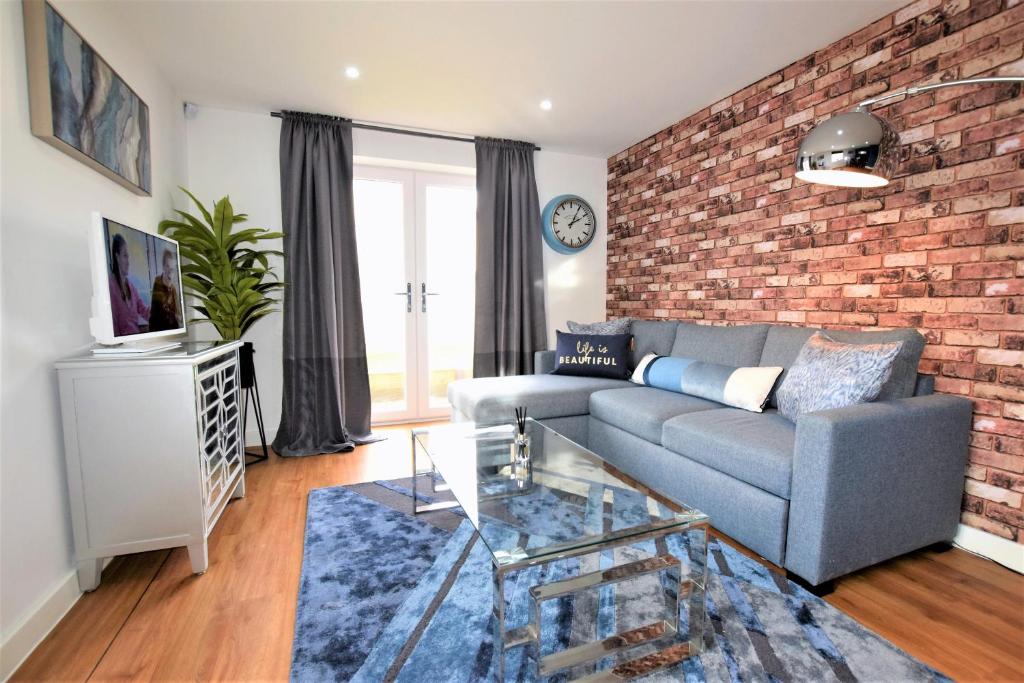 a living room with a couch and a brick wall at Savoy Court - Free Parking in Bristol