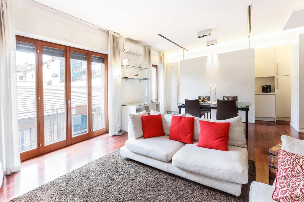 a living room with a white couch and red pillows at Bright and Cozy Apartment in Isola District - Marco Polo in Milan