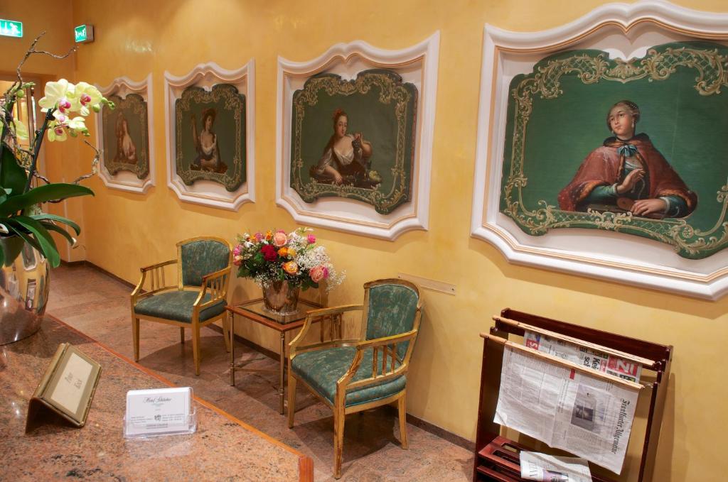 a room with portraits of people on the wall at Hotel Schlicker in Munich