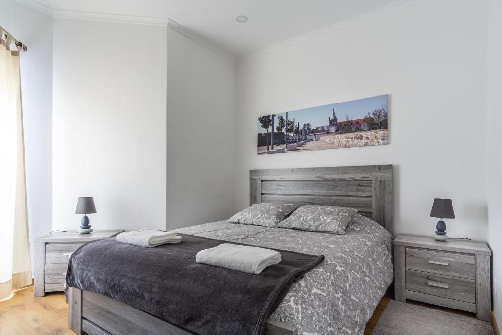 um quarto com uma cama grande e 2 mesas de cabeceira em 4U Alojamento - Terraço & Varanda em Abrantes