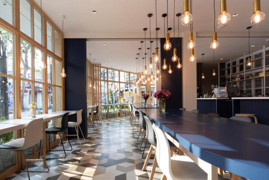 comedor grande con mesa larga y sillas en Boxpackers Hostel Phranakorn, en Bangkok