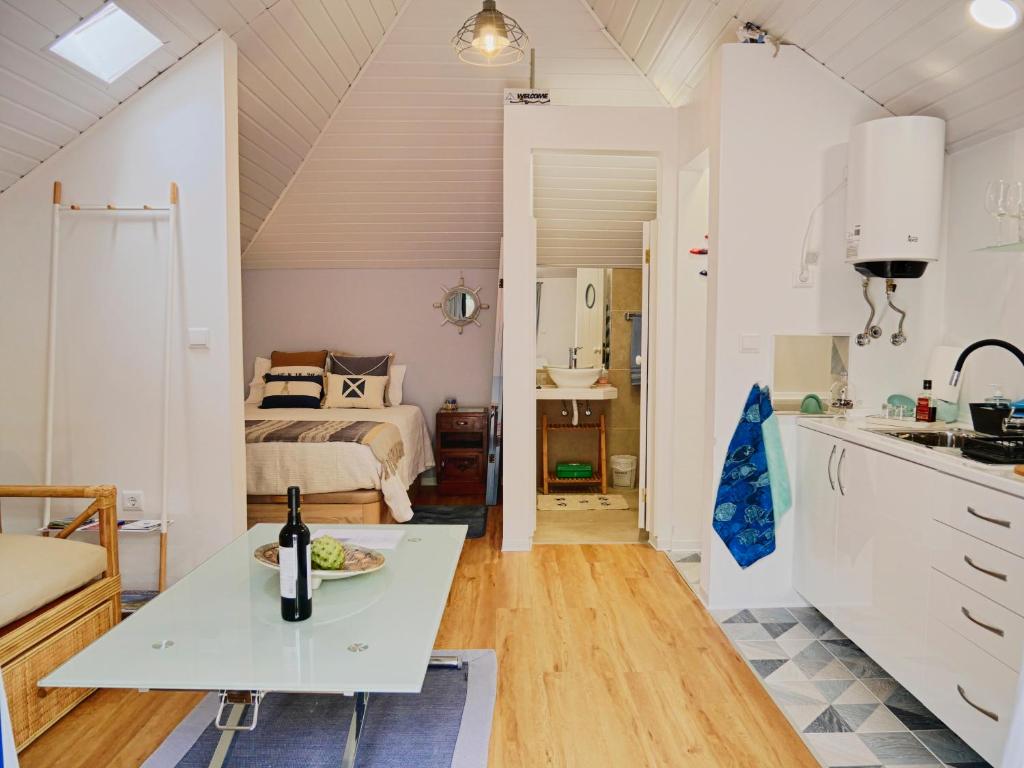 a kitchen and a bedroom with a bed and a table at Casa do pescador in Machico