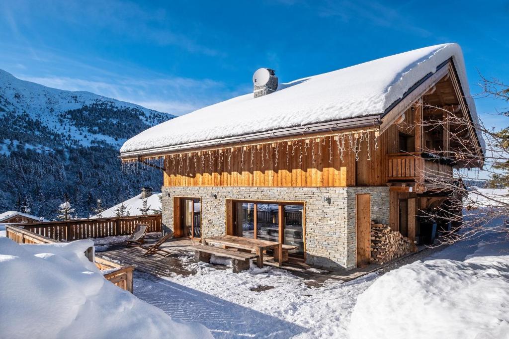 メリベルにあるChalet Zebraの屋根に雪が積もった丸太キャビン