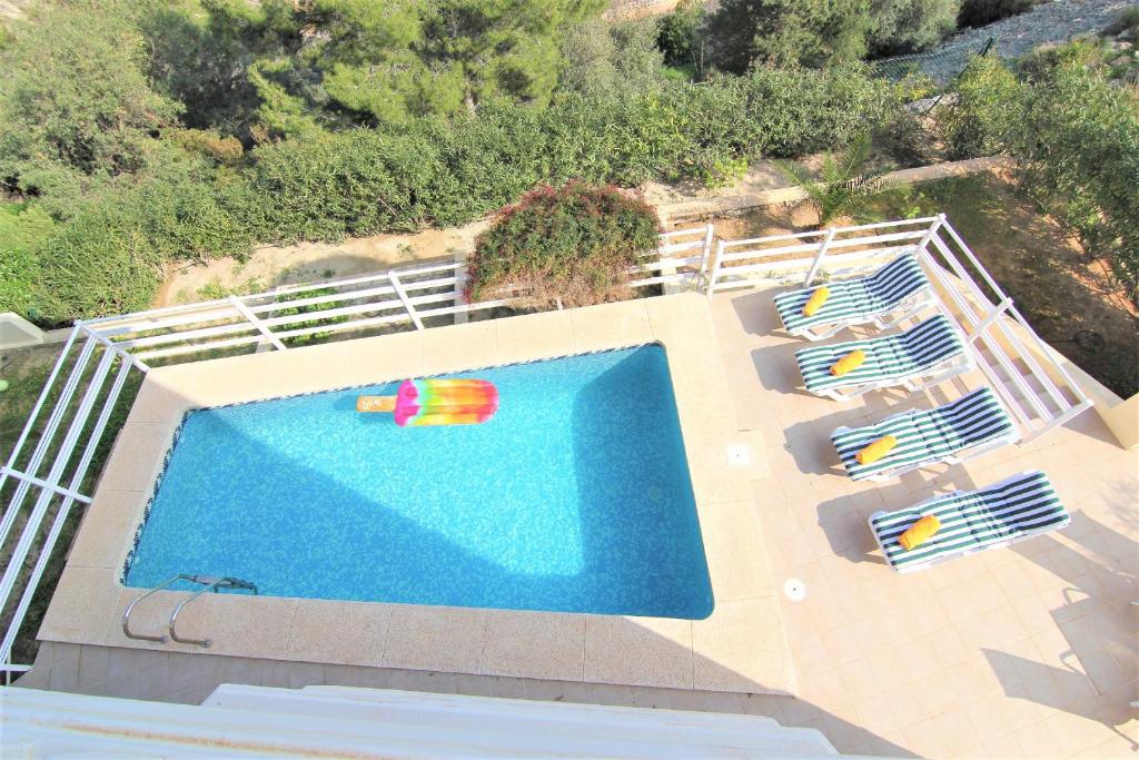 uma vista sobre uma piscina com cadeiras e uma piscina em Maryvilla 1220 em Calpe