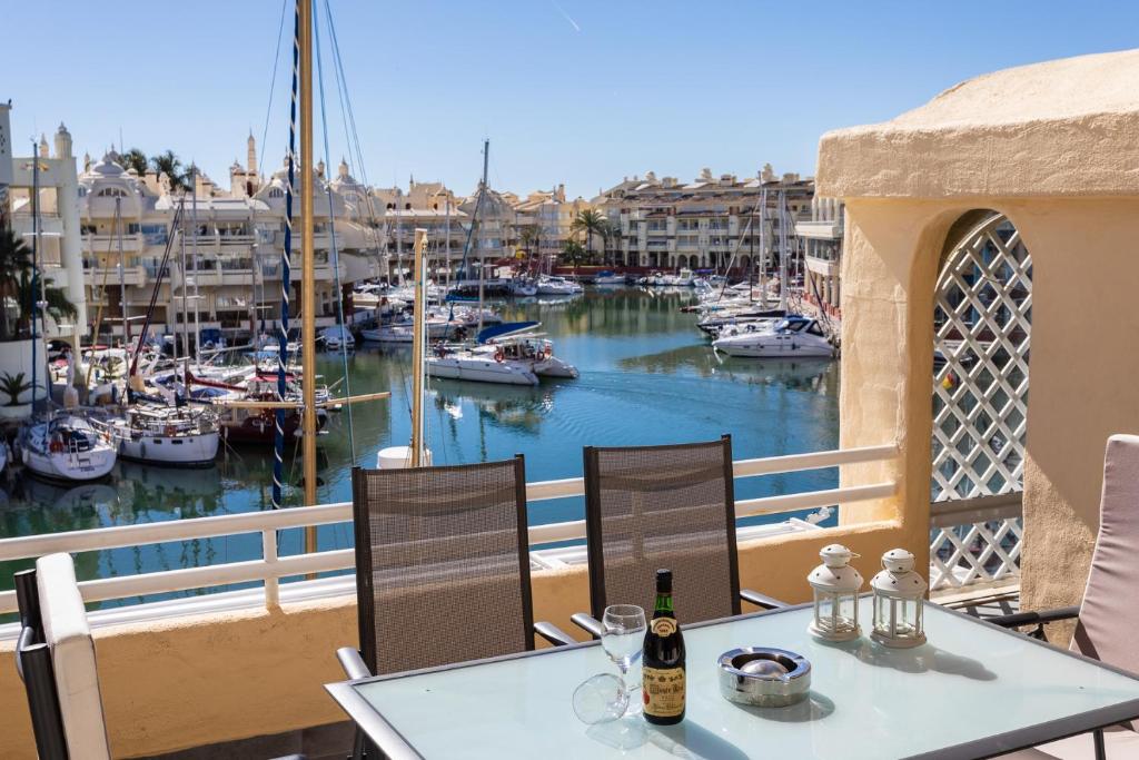 un balcon avec une table et des chaises et un port de plaisance dans l'établissement Magnifico apartamento con vistas en Puerto Marina, à Benalmádena