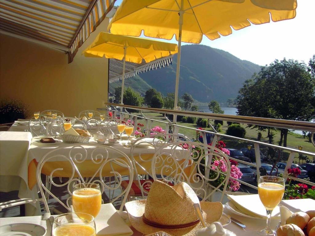 una mesa con vasos de zumo de naranja en el balcón en Garni Hotel Moselschild, en Ürzig
