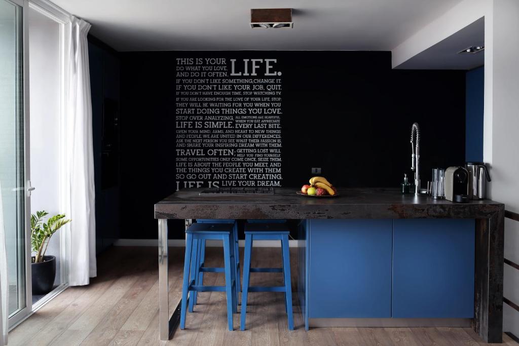 a kitchen with a counter with blue stools at Premium Family Villas "Sea & Sun" in Adeje