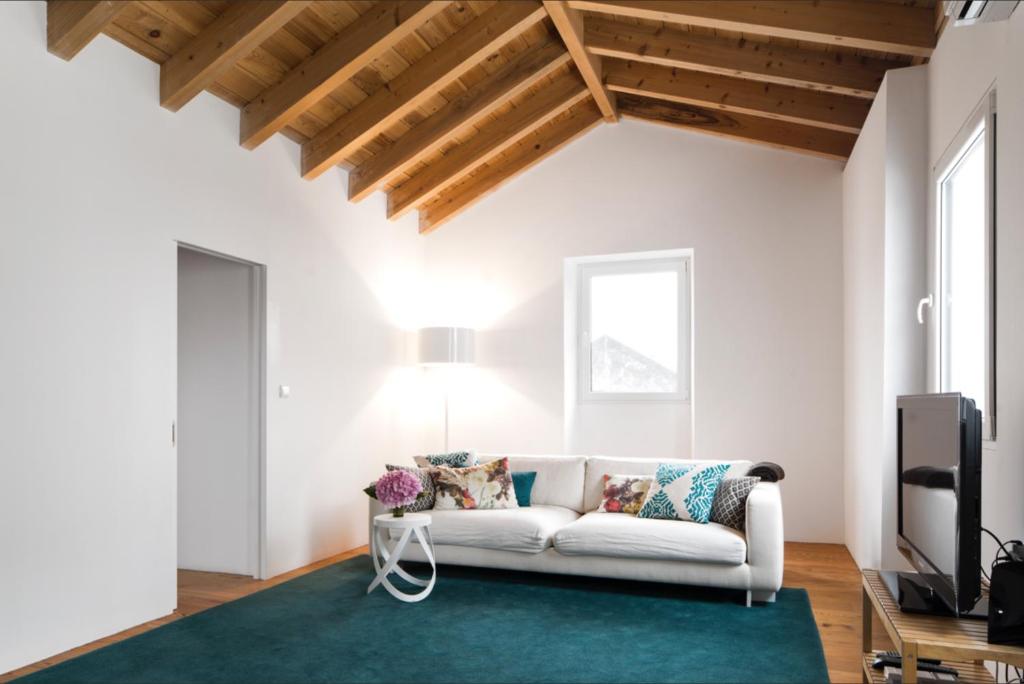 sala de estar con sofá blanco y alfombra verde en Baía das Caldeirinhas, en Horta