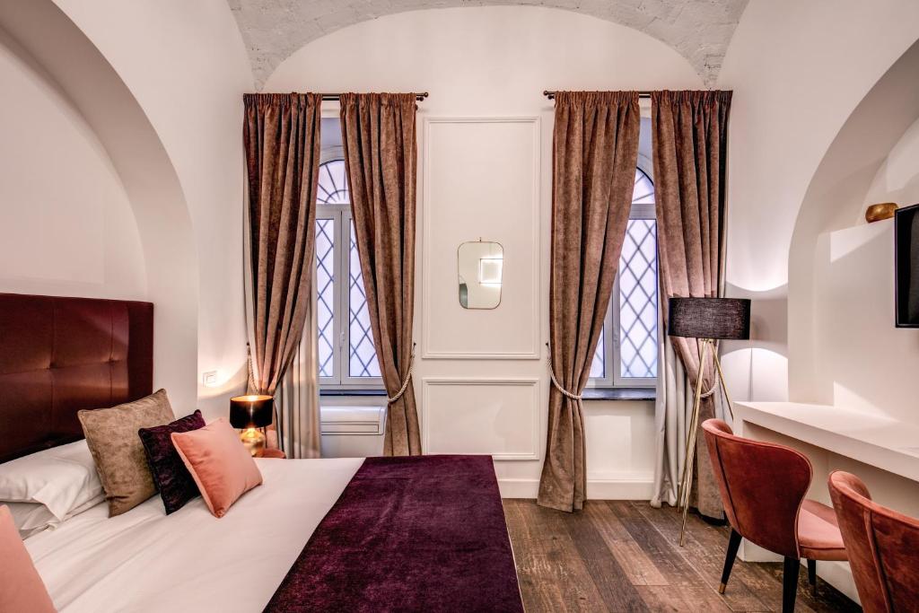 ローマにあるブティック チェントラーレ ルレのベッドルーム1室(ベッド1台、窓2つ付)