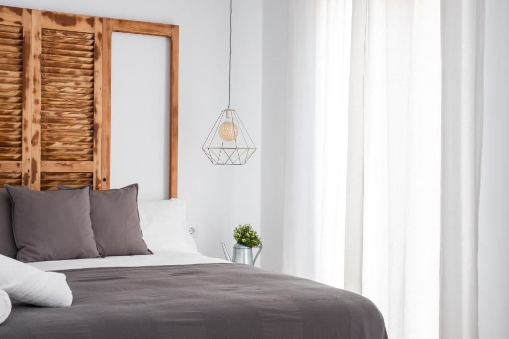 een slaapkamer met een bed met een houten hoofdeinde bij GOMEZ ROOMS in Xàtiva