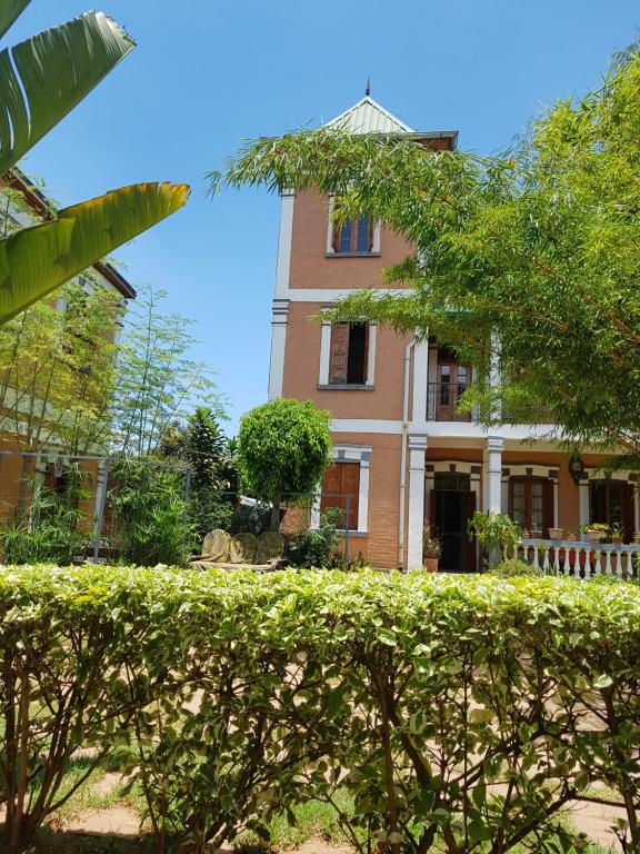 un edificio con un seto delante de él en Meva Guesthouse en Antananarivo