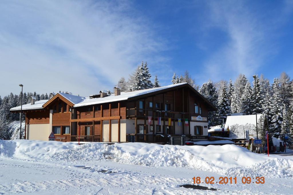 a house with snow in front of it at DOLOMITI appart&rooms in Varena