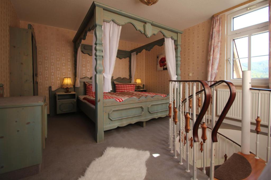 een slaapkamer met een hemelbed en een raam bij Hotel SchwarzaBurg in Schwarzburg