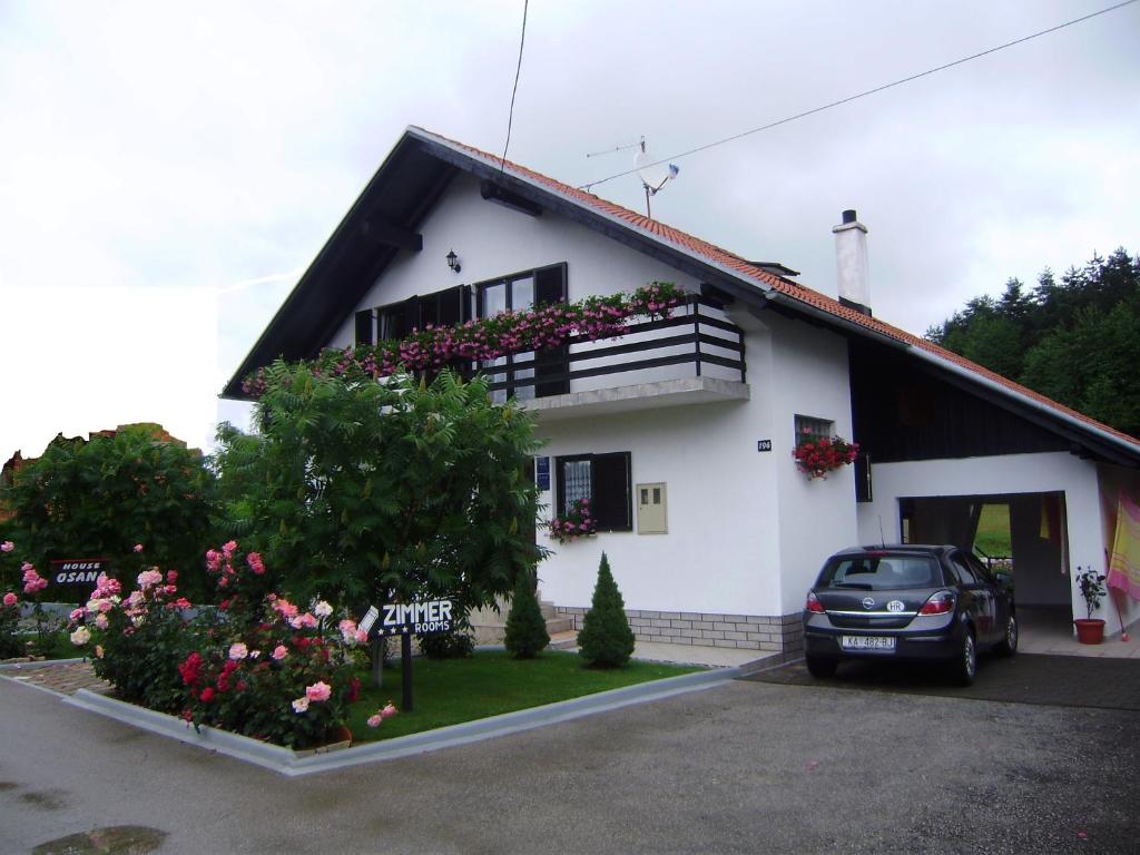 una casa blanca con un coche aparcado delante de ella en House Osana, en Grabovac