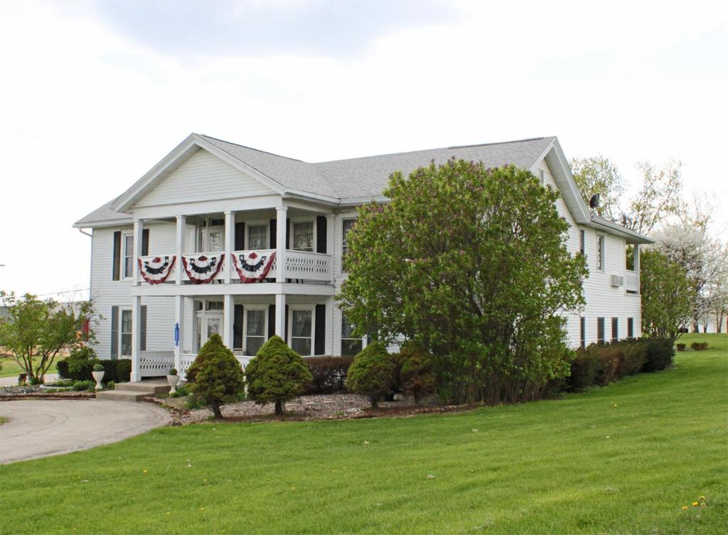a white house with american flags on it at Belle Aire Mansion Guest House in Galena