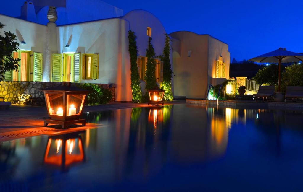 uma piscina com velas acesas em frente a um edifício em Pleiades Eco Houses em Vóthon