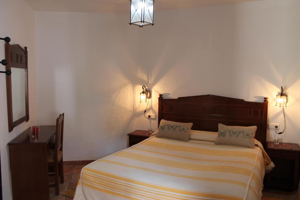 a bedroom with a bed with two night stands and two lamps at La Tila in Capileira