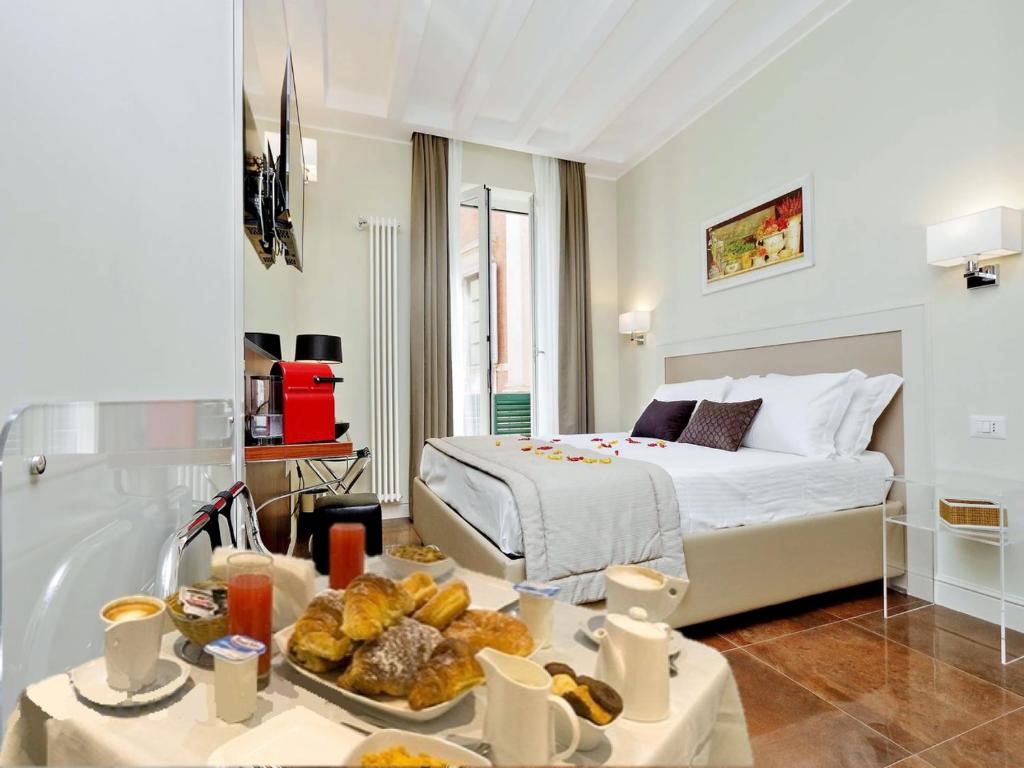 ローマにあるPiazza Venezia Grand Suiteのベッドとテーブル(食べ物付)が備わる客室です。