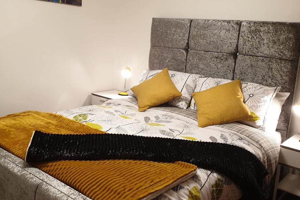 a bed with two pillows and a blanket on it at The Beach Apartment, near Outlander location in Kirkcaldy