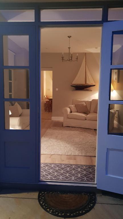 a living room with a blue door and a couch at The Coach House Douglas in Cork