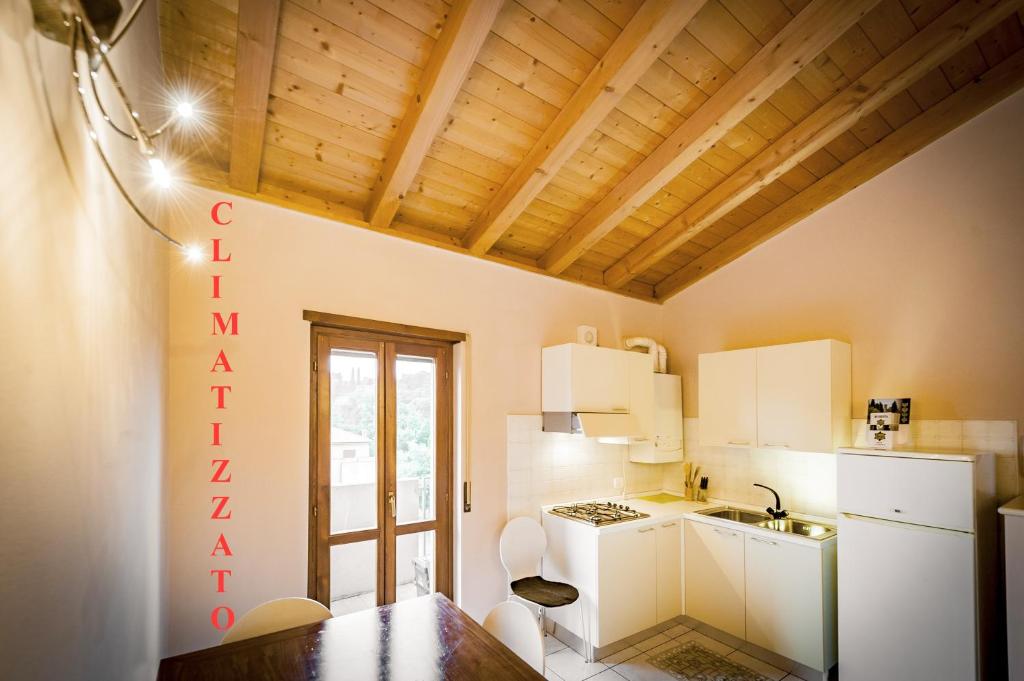 una cucina con elettrodomestici bianchi e soffitto in legno di casabelvedere a Valeggio sul Mincio