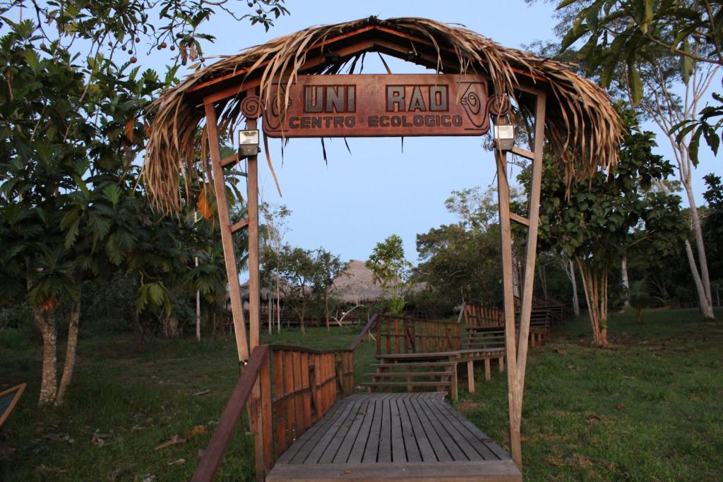 a wooden gazebo with a bench and a sign at Uni Rao Centro Ecológico in Pucallpa