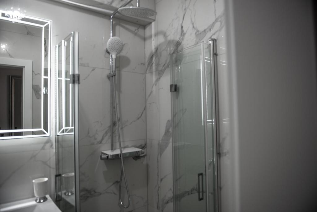 łazienka z prysznicem i szklanymi drzwiami w obiekcie Glamour Apartments w mieście Piła