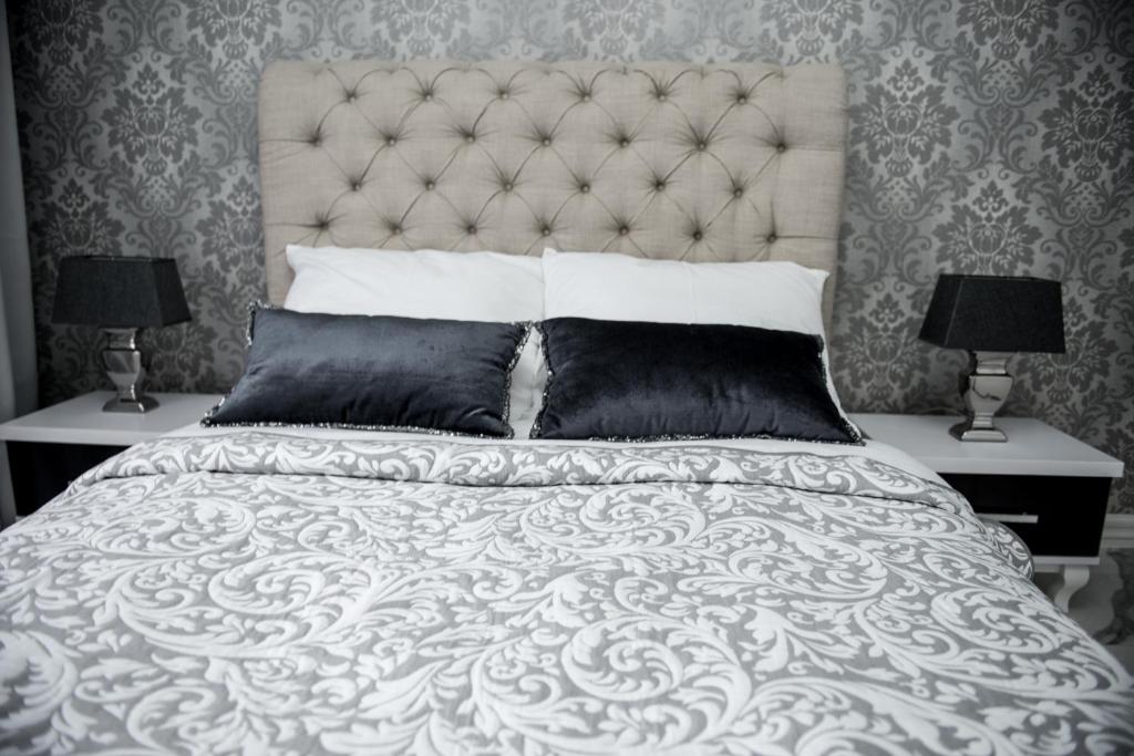 sypialnia z dużym białym łóżkiem i dwiema lampami w obiekcie Glamour Apartments w mieście Piła
