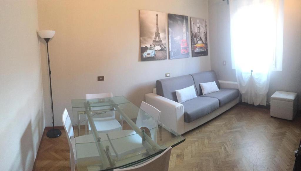 un soggiorno con divano e tavolo in vetro di Casa Casò Guest House a Bologna