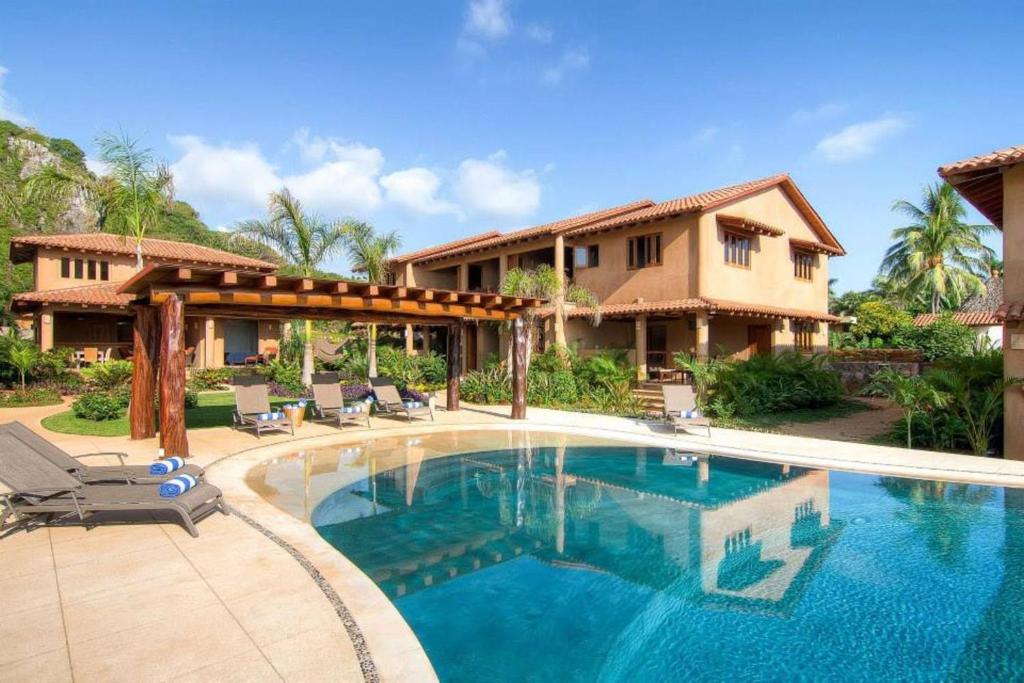 a swimming pool in front of a house at Las Villas, Villa Alegria,Troncones in Troncones