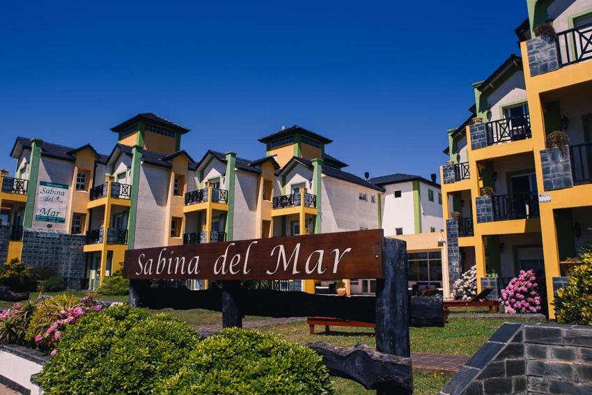 a sign in front of a row of apartment buildings at Apart Sabina del Mar in Mar de Ajó