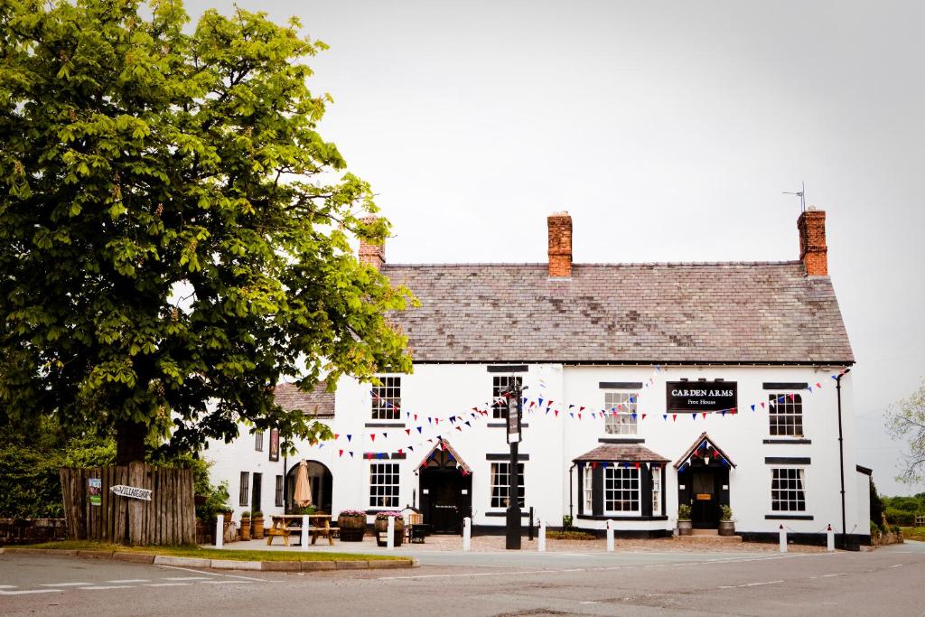 a large white building with flags on it at The Carden Arms in Tilston