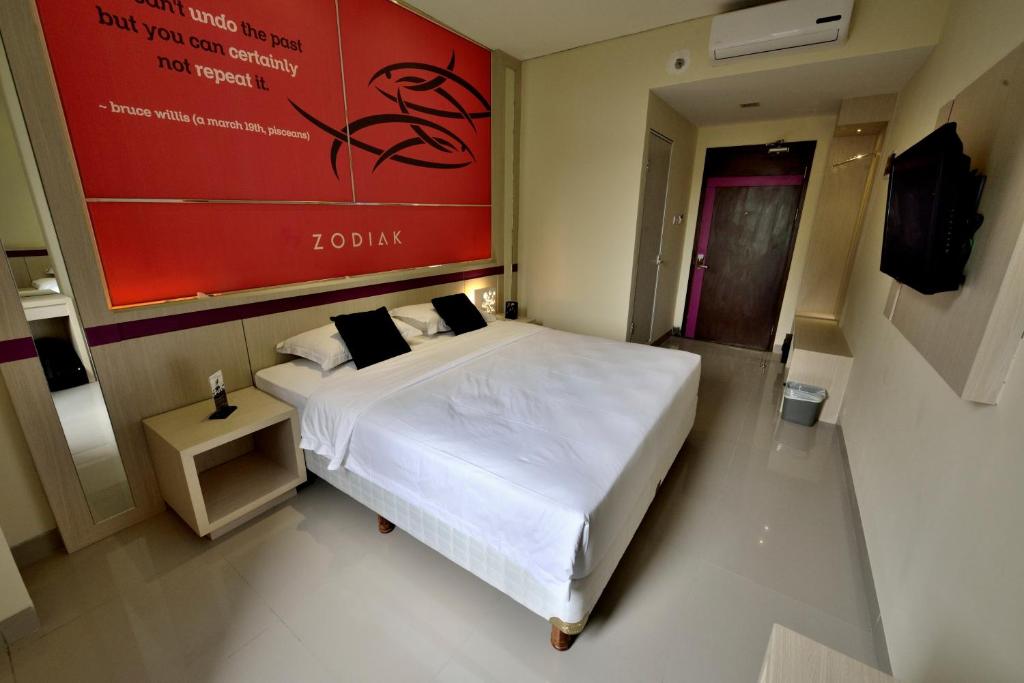 Postel nebo postele na pokoji v ubytování Zodiak Kebon Kawung by KAGUM Hotels