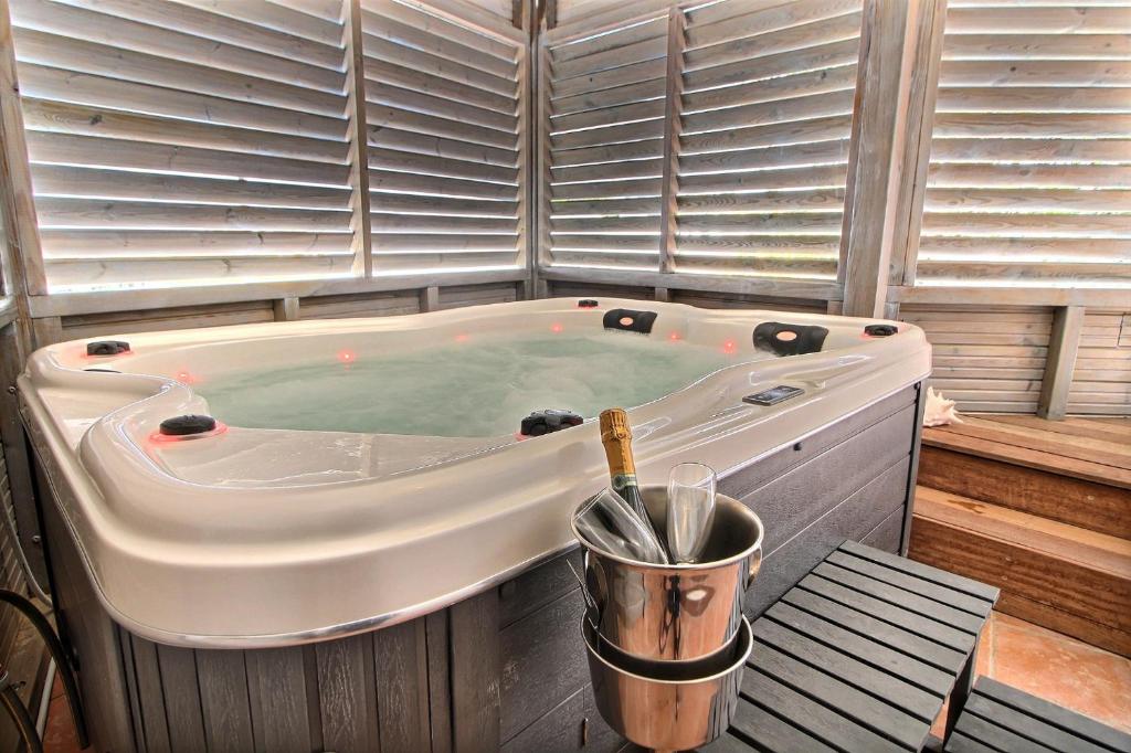 a jacuzzi tub in a room with windows at Appartement THOMANA , jacuzzi privé, plage à 200 m in Le Moule