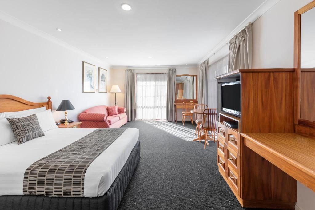 Best Western Ambassador Motor Inn & Apartments في واجا واجا: غرفة فندقية بسرير وتلفزيون بشاشة مسطحة