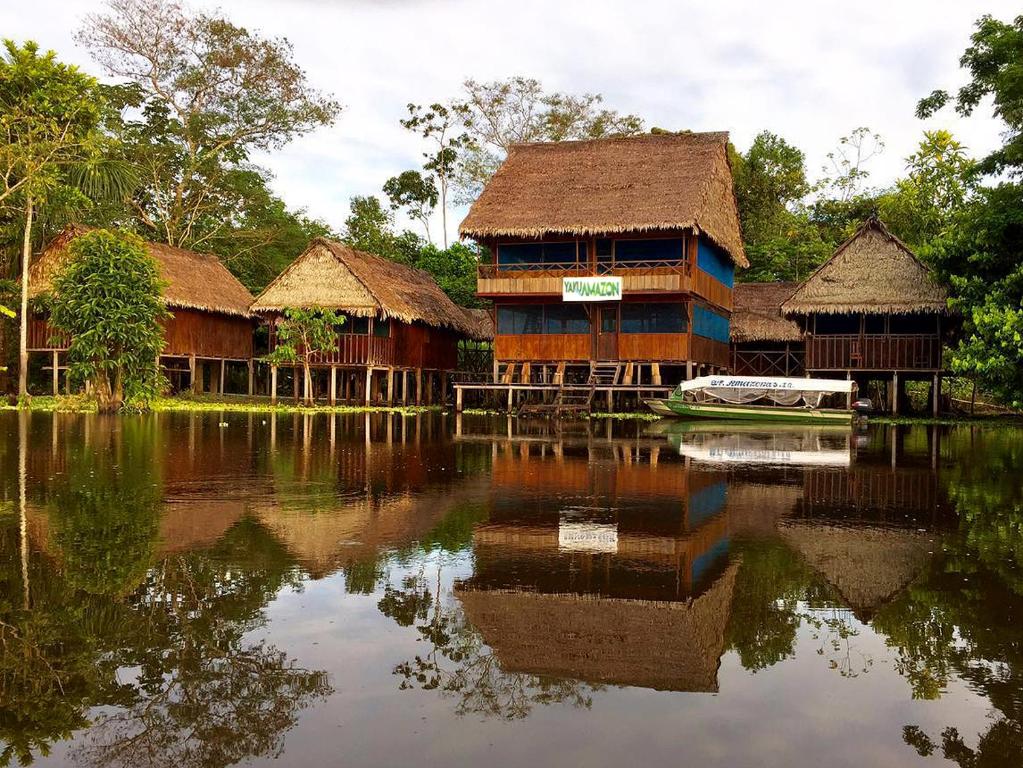 Yaku Amazon Lodge & Expeditions في Paraíso: مجموعة مباني بجانب تجمع المياه